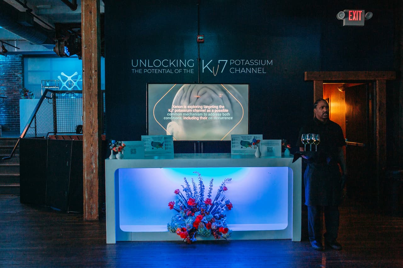 Corporate reception with blue-lit bar and presentation wall